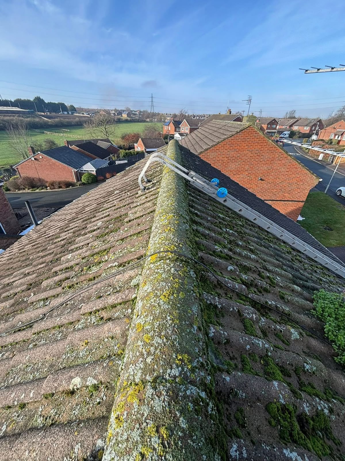 Roof moss removal Glasgow: heavy moss growth across a concrete tile roof before cleaning
